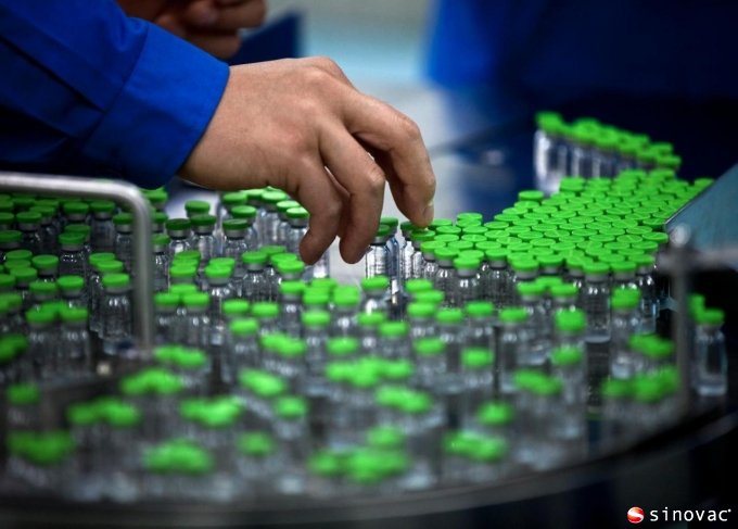 a worker inspects labels on vials containing H5N1 flu vaccine during production at the Beijing-based drug maker Sinovac Biotech Ltd. in Beijing